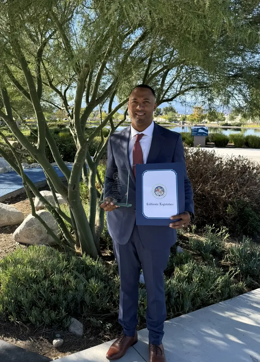 Kevin holding the Recognition of Service to Youth award and a California Legislature certificate