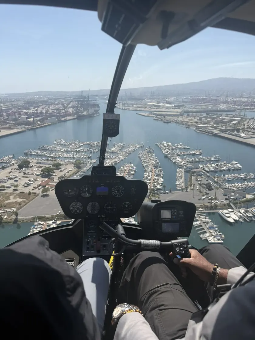View from a helicopter cockpit over a marina