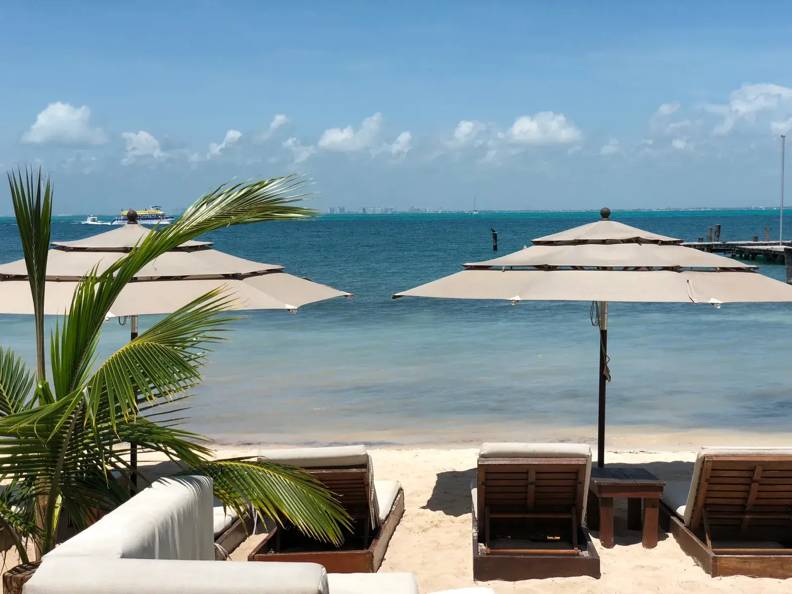 Beach umbrellas and lounge chairs facing turquoise water