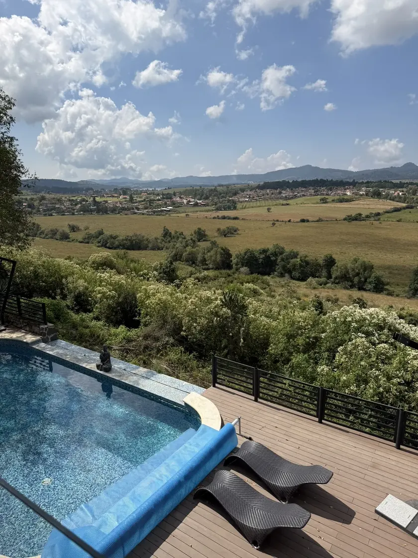 Infinity pool overlooking a green mountain valley